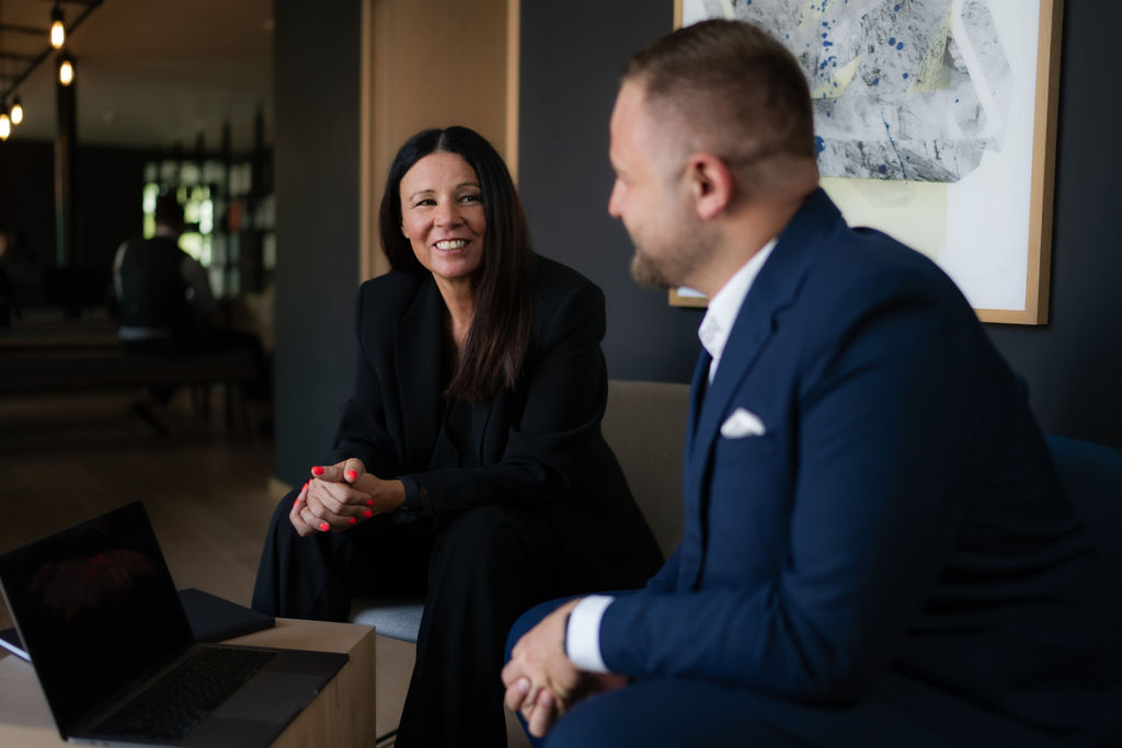 Troi leadership team in a business meeting discussing project strategy and professional services automation in a modern office lounge setting