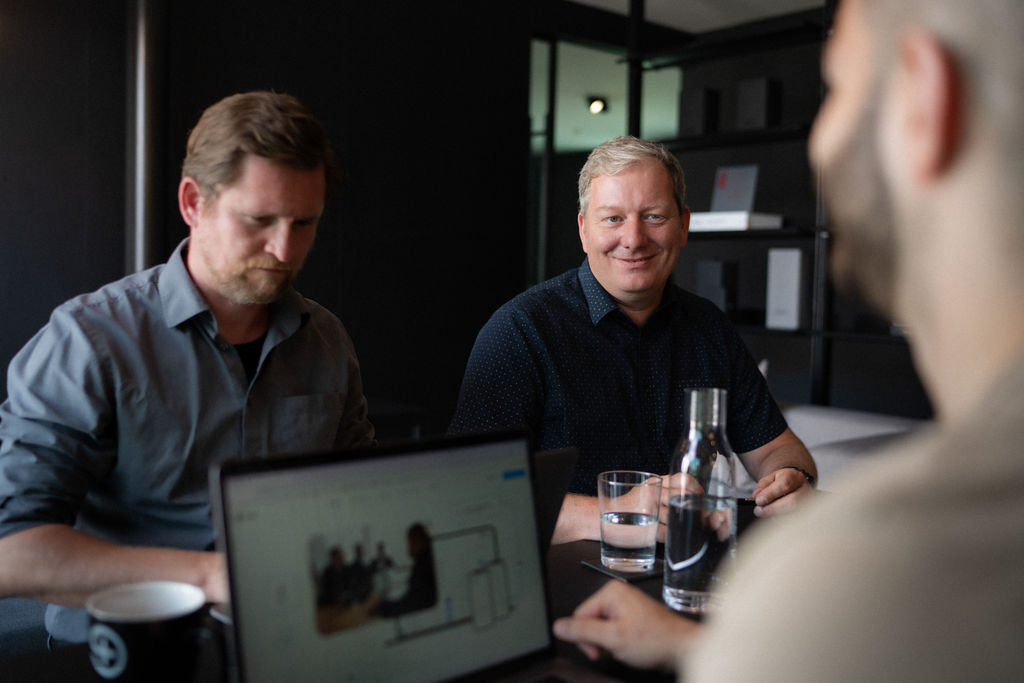 Team meeting with Troi employees discussing project planning and digital workflows in a modern office environment, showing collaboration, consulting and professional services management with Troi PSA